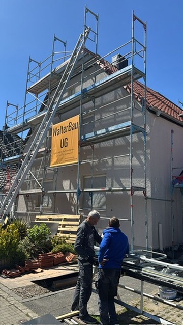 Mitarbeiter der Walter Bau UG bei Sanierungsarbeiten an einem eingerüsteten Wohnhaus