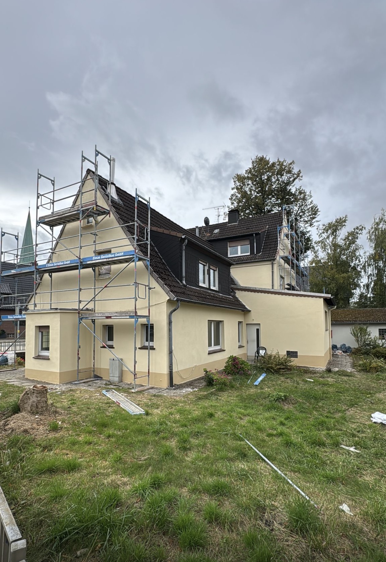 Frisch gestrichene Fassade mit abgesetztem Sockel: Fassadensanierung der Walter Bau UG in Dortmund